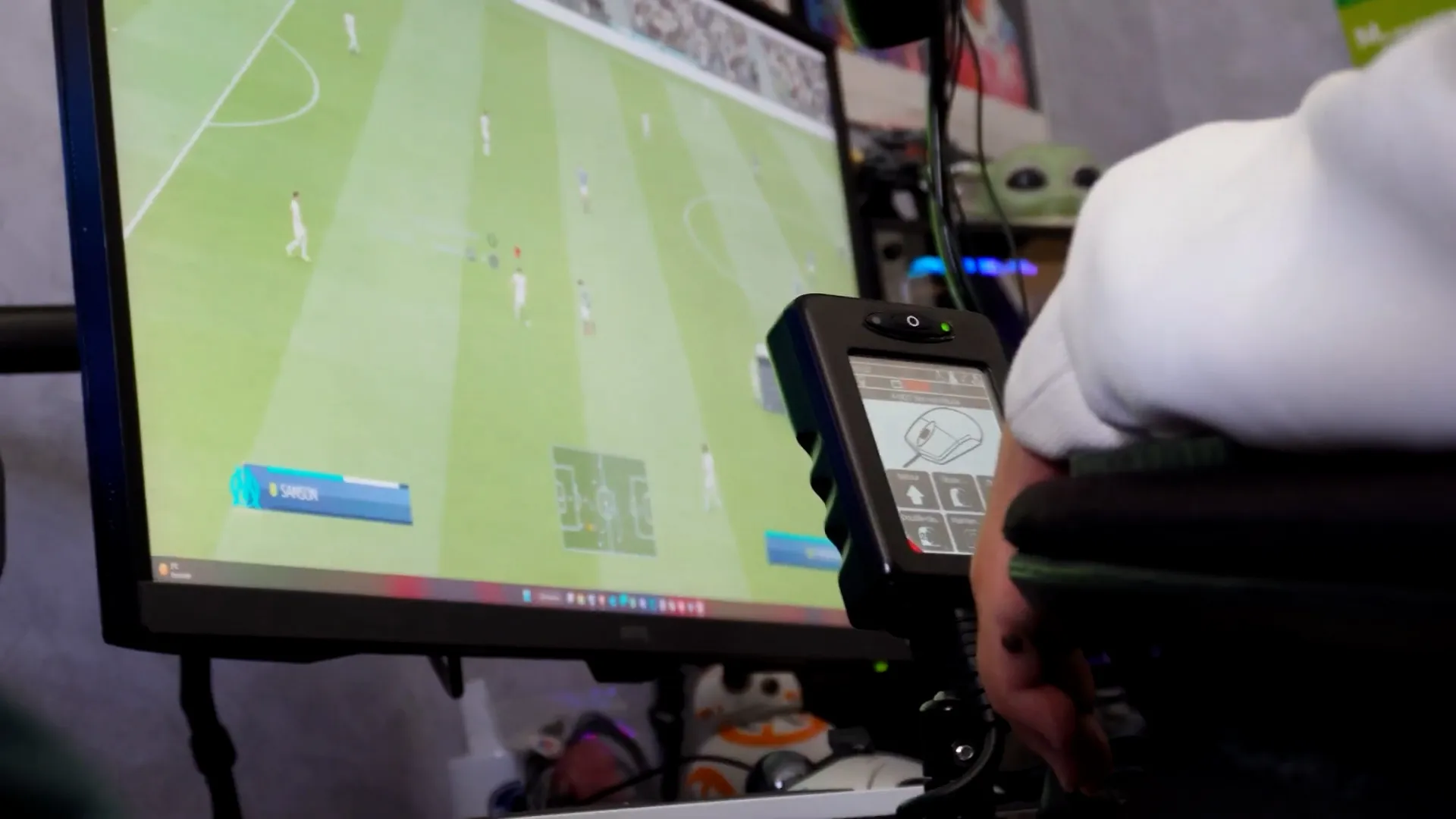 Matthieu playing a football game on a PC with his wheelchair joystick.