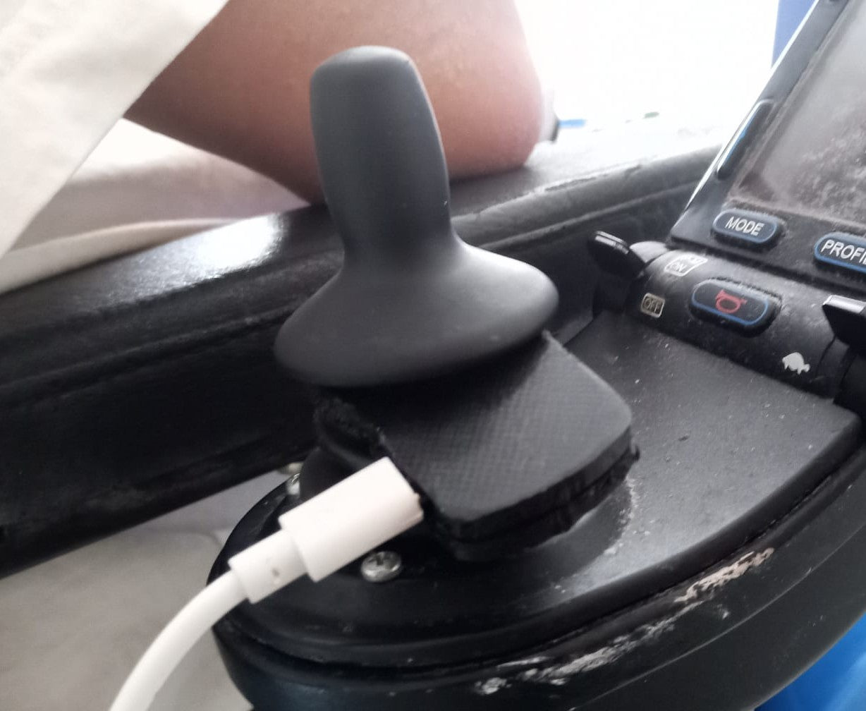 MoveStick mounted beneath a wheelchair joystick.